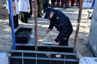Komendant Policji w Wysokiem Mazowieckiem wmurowuje tubę z aktem erekcyjnym