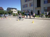 Fotografia przedstawia funkcjonariuszy Wydziału Ruchu Drogowego przeprowadzających  testy praktyczne z uczniami na kartę rowerową w Czyżewie