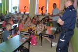 Fotografia przedstawia przedstawicieli Policji, Krus-u oraz PSSE prowadzących spotkanie z dziećmi
