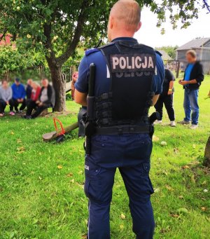 Obraz przedstawia policjanta na spotkaniu z seniorami