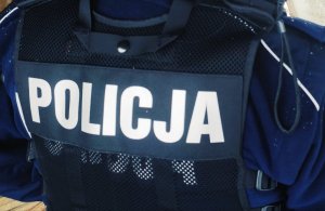 Obraz przedstawia napis policja z kurtki zimowej policjanta