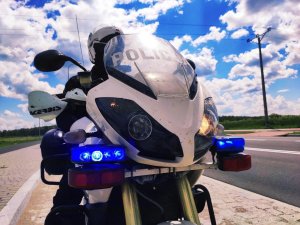 Obraz przestawia policjanta na motocyklu
