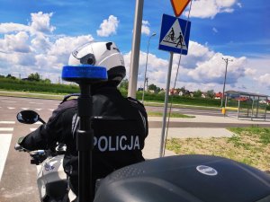 obraz przedstawia policjanta jadącego na motocyklu