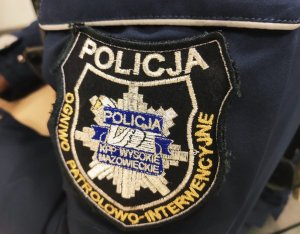 obraz przedstawia naszywkę na ramieniu policjanta z napisem Ogniwo-Patrolowo-Interwencyjne Komendy Powiatowej Policji  w Wysokiem Mazowieckiem