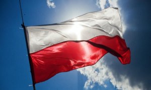 obraz przedstawia flagę Polski na niebieskim tle