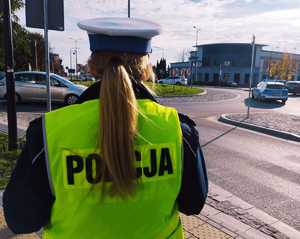 obraz przedstawia policjantkę obserwującą przejście dla pieszych