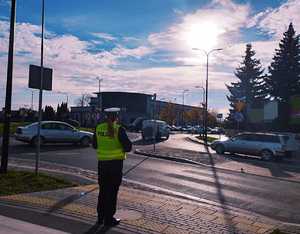 obraz przedstawia policjanta obserwującego przejście dla pieszych