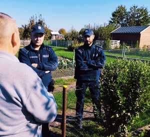 obraz przedstawia policjantów rozmawiających z mężczyzną