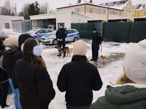 obraz przedstawia policjantów przewodników psów służbowych z młodzieżą