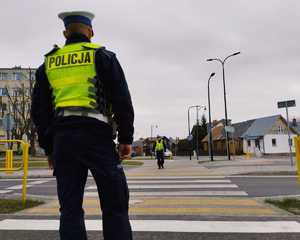 obraz przedstawia policjantów ruchu drogowego obserwujących przejście dla pieszych