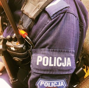 obraz przedstawia ramię policjanta z napisem policja