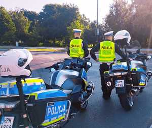 obraz przedstawia policjantów stojących przy motocyklach