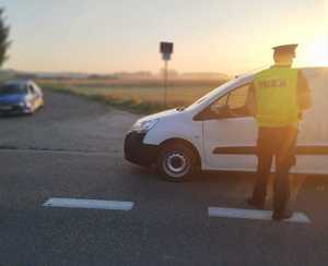obraz przedstawia policjanta , który dokonuje sprawdzenia stanu trzeźwości kierowcy pojazd osobowego
