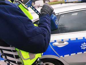 obraz przedstawia dłonie policjanta trzymające urządzenie do pomiaru prędkości