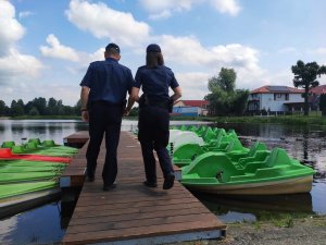 obraz przedstawia policjantów na tle zbiornika wodnego