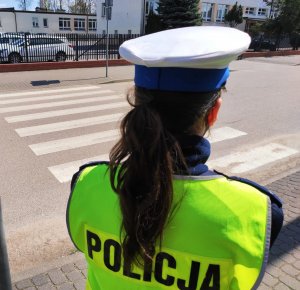 obraz przedstawia policjantkę stojącą przed przejściem dla pieszych