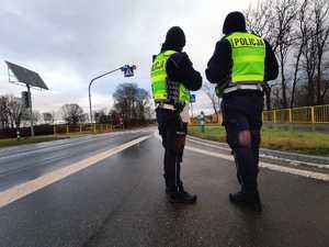 obraz przedstawia policjantów stojących na drodze