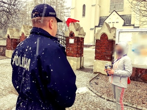 obraz przedstawia policjanta rozmawiającego z wolontariuszami  Wielkiej Orkiestry Świątecznej Pomocy