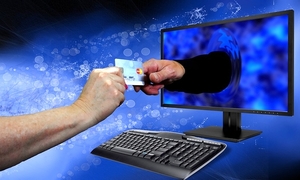 obraz przedstawia dłonie na niebieskim tle przekazujące sobie kartę, w tle klawiatura oraz monitor komputera