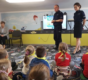 obraz przedstawia policjantów z dziećmi w sali edukacyjnej