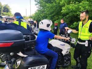 obraz przedstawia policjantów z dziećmi siedzącymi na motocyklach