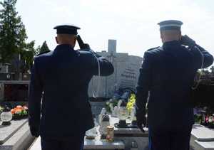 obraz przedstawia policjantów na cmentarzu oddających hołd zmarłemu