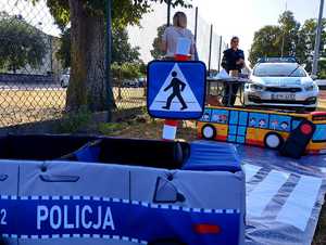 obraz przedstawia policjantkę stojącą przy stoisku profilaktycznym  w Jabłoni Kościelnej