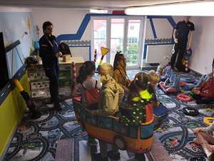 obraz przedstawia policjantkę z dziećmi w sali edukacyjnej