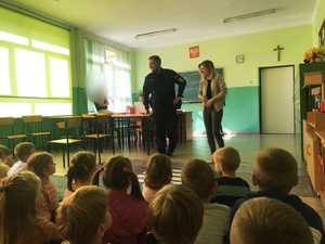 obraz przedstawia policjanta i profilaktyk  na spotkaniu z dziećmi