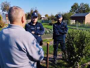 obraz przedstawia policjantów rozmawiających z mężczyzną