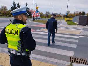 obraz przedstawia policjanta obserwującego przejście dla pieszych