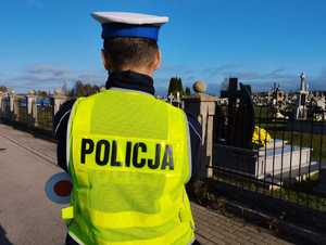 obraz przedstawia policjanta patrzącego  na cmentarz