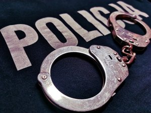 obraz przedstawia kajdanki na tle napisu policja