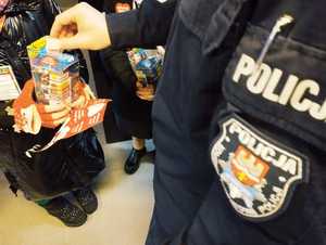obraz przedstawia policjanta wrzucającego pieniądze do puszki 31. Finału Wielkiej Orkiestry Świątecznej Pomocy