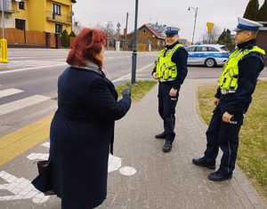 obraz przedstawia policjantów ruchu drogowego obserwujących przejście dla pieszych