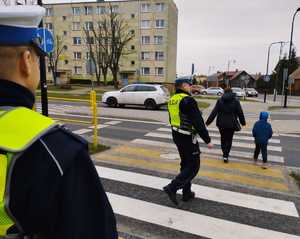 obraz przedstawia policjantów ruchu drogowego obserwujących przejście dla pieszych