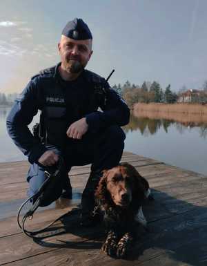 obraz przedstawia policjanta z psem