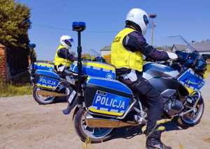 obraz przedstawia policjanta siedzącego na motocyklu