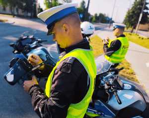 obraz przedstawia policjantów patrzących na drogę