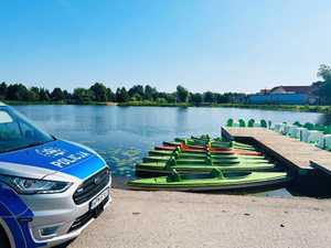 obraz przedstawia radiowóz na tle zbiornika wodnego