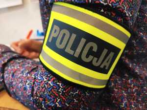 obraz przedstawia opaskę na ramieniu policjanta z napisem policja