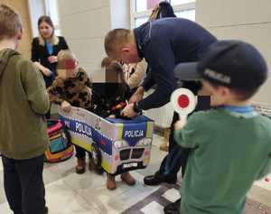 obraz przedstawia policjantów podczas 32. Finału Wielkiej Orkiestry Świątecznej Pomocy z dziećmi