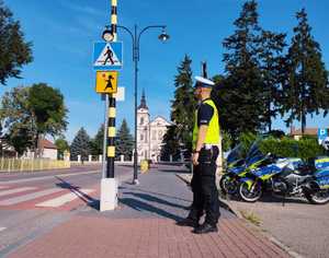 obraz przedstawia policjanta i motocykl