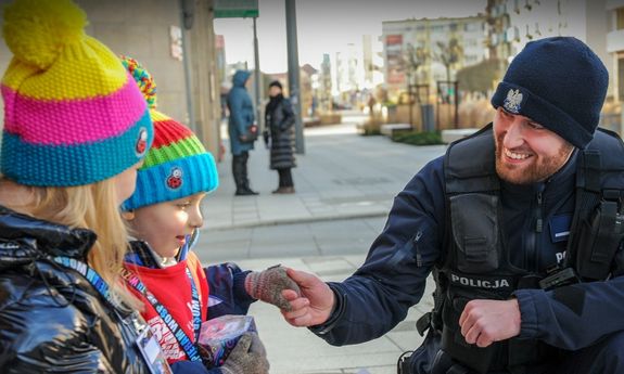 obraz przedstawia policjanta i dwójkę dzieci