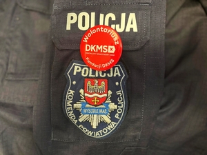 obraz przedstawia napis policja i przywieszkę DKMS