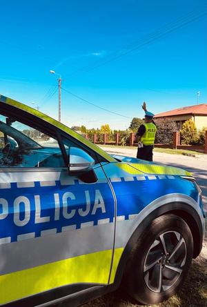 obraz przedstawia policjanta podającego sygnał do zatrzymania