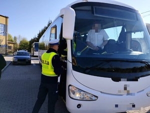obraz przedstawia policjanta i autobus