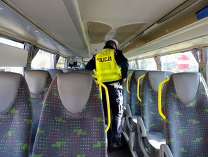 obraz przedstawia policjanta i autobus