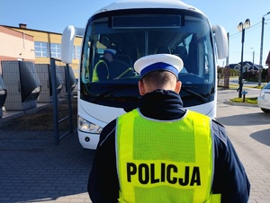 obraz przedstawia policjanta i autobus