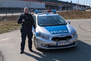 obraz przedstawia radiowóz i policjanta